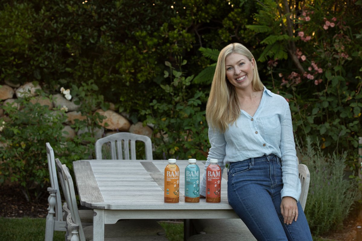 Founder seated at outdoor table with bottled drinks lifestyle branding photography san diego by Siobhan Gazur Photography