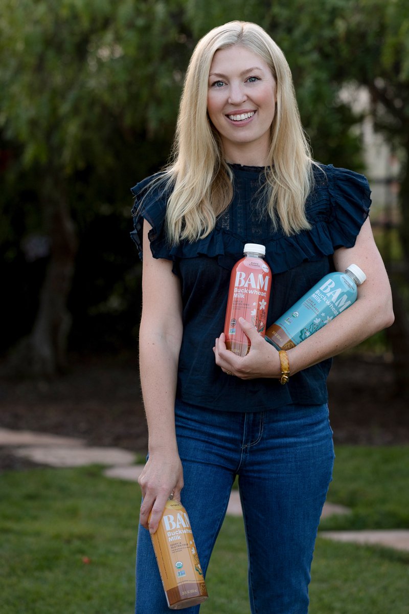 PersPersonal branding portrait of a founder holding bottled drinks outdoors san diego branding photography by Siobhan Gazur Photography