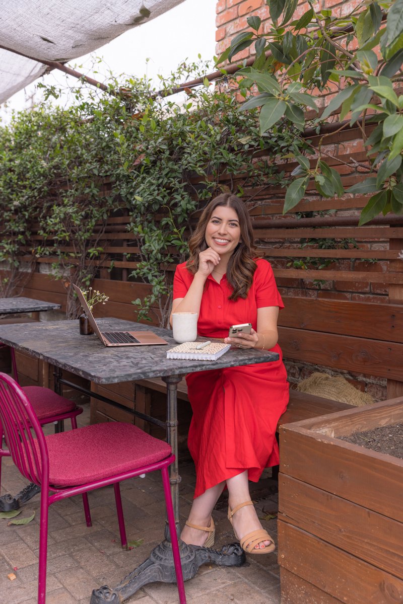 Entrepreneur seated outdoors in a red outfit during a personal branding session san diego branding photography by Siobhan Gazur Photography
