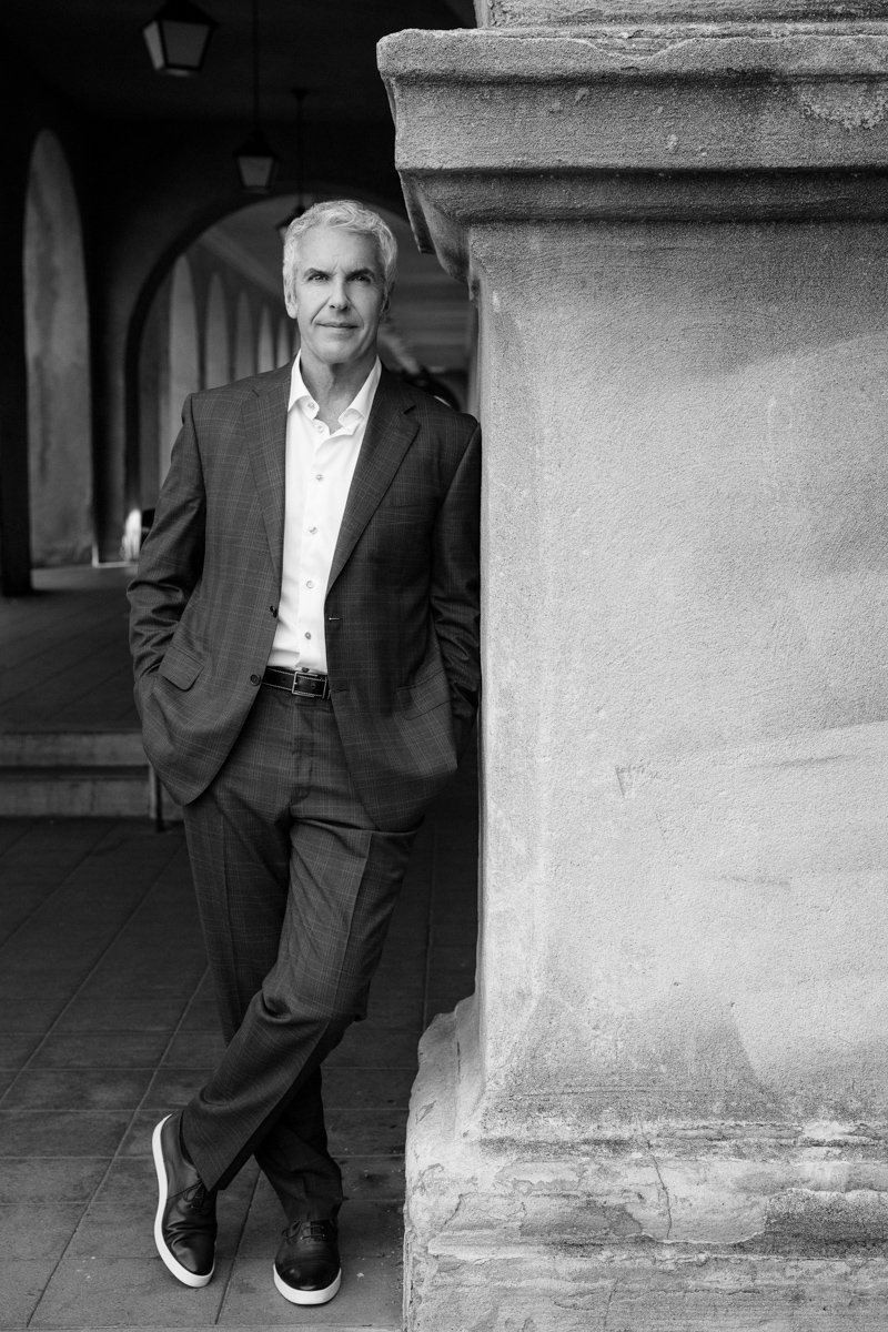 Black-and-white on-location branding portrait of a businessman near architectural columns san diego branding photography by Siobhan Gazur Photography